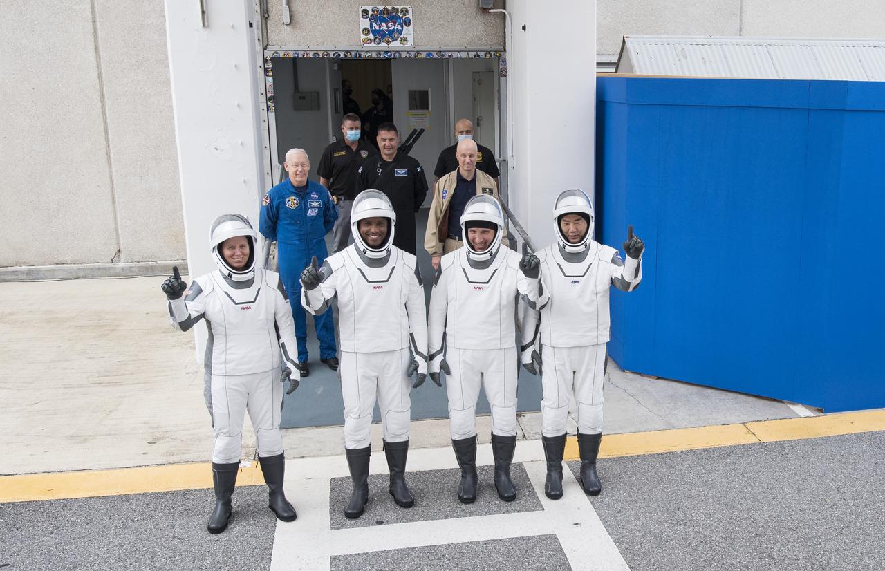 NASA astronauts Shannon Walker, left, Victor Glover, second from left, Mike Hopkins, second from right, and Japan Aerospace Exploration Agency (JAXA) astronaut Soichi Noguchi, right, wearing SpaceX spacesuits, stop to pose for a picture as walk out of the Neil  A. Armstrong Operations and Checkout Building to depart for Launch Complex 39A during a dress rehearsal prior to the Crew-1 mission launch, Thursday, Nov. 12, 2020, at NASA’s Kennedy Space Center in Florida. NASA’s SpaceX Crew-1 mission is the first operational mission of the SpaceX Crew Dragon spacecraft and Falcon 9 rocket to the International Space Station as part of the agency’s Commercial Crew Program. NASA astronauts Mike Hopkins, Victor Glover, and Shannon Walker, and astronaut Soichi Noguchi of the Japan Aerospace Exploration Agency (JAXA) are scheduled to launch at 7:49 p.m. EST on Saturday, Nov. 14, from Launch Complex 39A at the Kennedy Space Center. Photo Credit: (NASA/Joel Kowsky)