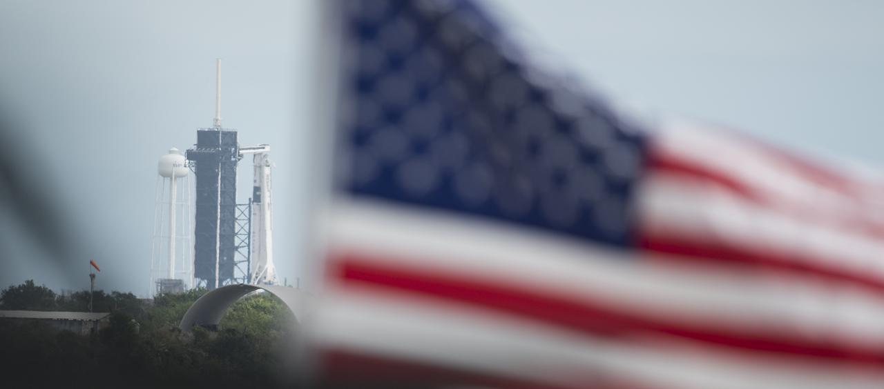 A SpaceX Falcon 9 rocket carrying the company’s Crew Dragon spacecraft is seen during a press conference ahead of the Crew-1 launch, Friday, Nov. 13, 2020, at NASA’s Kennedy Space Center in Florida. NASA’s SpaceX Crew-1 mission is the first crew rotation mission of the SpaceX Crew Dragon spacecraft and Falcon 9 rocket to the International Space Station as part of the agency’s Commercial Crew Program. NASA astronauts Mike Hopkins, Victor Glover, and Shannon Walker, and astronaut Soichi Noguchi of the Japan Aerospace Exploration Agency (JAXA) are scheduled to launch at 7:49 p.m. EST on Saturday, Nov. 14, from Launch Complex 39A at the Kennedy Space Center.  Photo Credit: (NASA/Joel Kowsky)