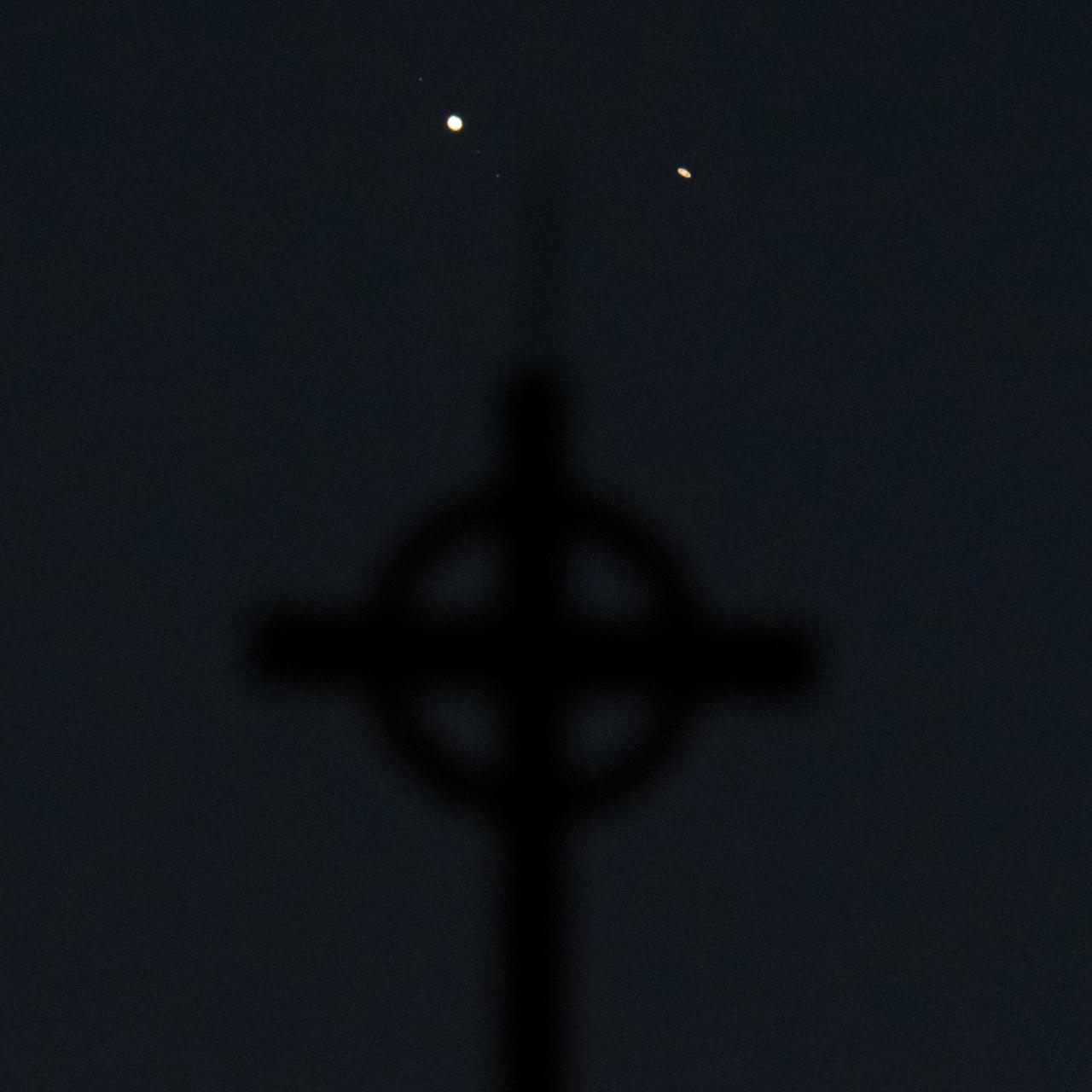 Jupiter, left, and Saturn, right, are seen above a steeple after sunset from Arlington, Va., Tuesday, Dec. 22, 2020. The two planets are now slowly separating from each other in the sky, after appearing a tenth of a degree apart during the "great conjunction" on December 21. Photo Credit: (NASA/Bill Ingalls)