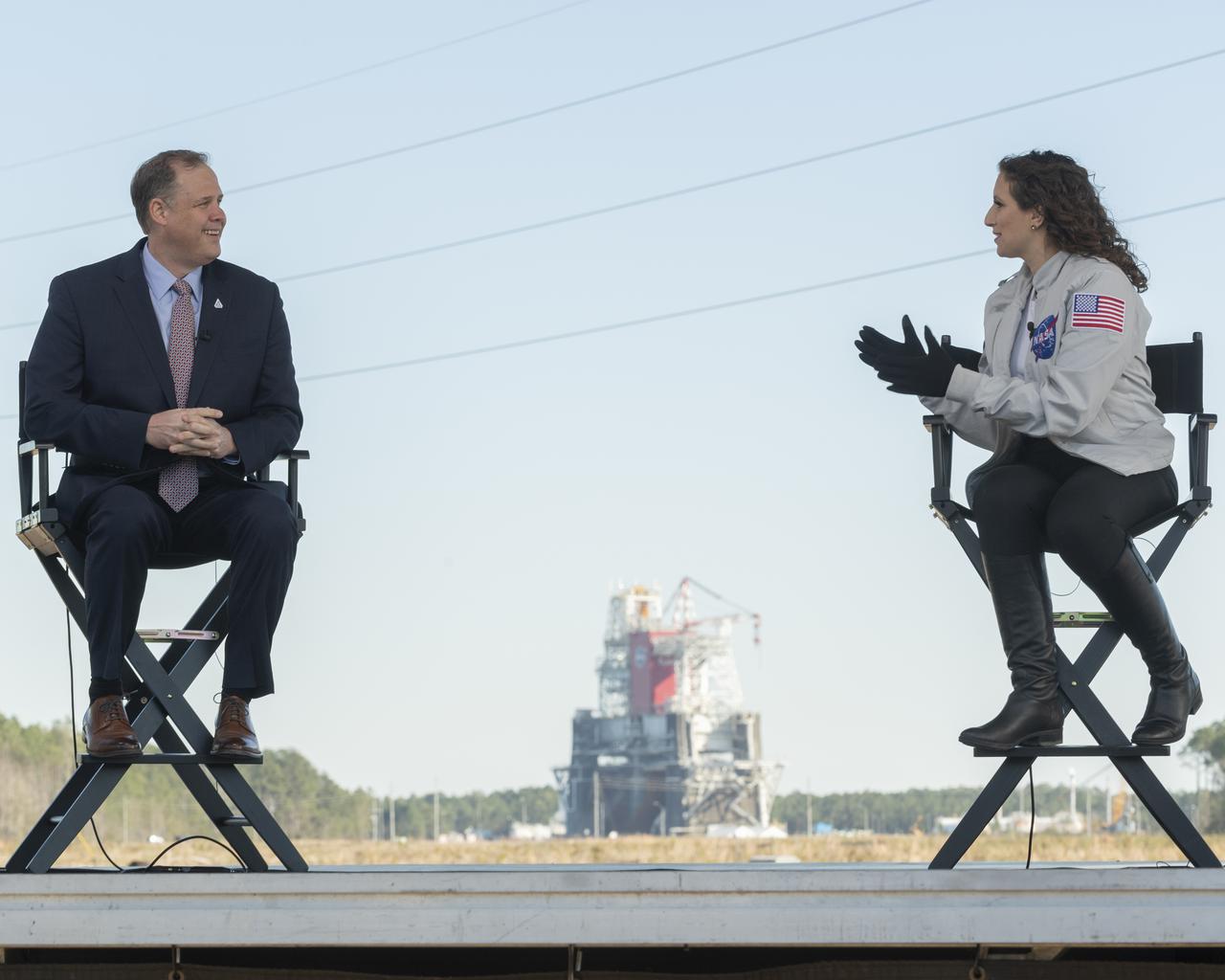 NASA Administrator Jim Bridenstine discusses the upcoming Green Run hot fire test on NASA television with Leigh D’Angelo of NASA, Saturday, January 16, 2021, at NASA's Stennis Space Center near Bay St. Louis, Mississippi. In the background, the core stage for the first flight of NASA’s Space Launch System rocket is seen in the B-2 Test Stand ahead of a scheduled eight minute duration hot fire test. The hot fire test is the final stage of the Green Run test series, a comprehensive assessment of the Space Launch System’s core stage prior to launching the Artemis I mission to the Moon.  Photo Credit: (NASA/Robert Markowitz)