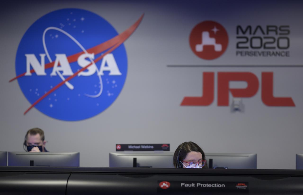 Members of NASA’s Perseverance Mars rover team study data on monitors in mission control, Thursday, Feb. 18, 2021, at NASA's Jet Propulsion Laboratory in Pasadena, California. A key objective for Perseverance’s mission on Mars is astrobiology, including the search for signs of ancient microbial life. The rover will characterize the planet’s geology and past climate, pave the way for human exploration of the Red Planet, and be the first mission to collect and cache Martian rock and regolith. Photo Credit: (NASA/Bill Ingalls)