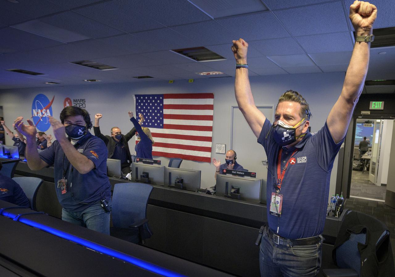Members of NASA’s Perseverance rover team react in mission control after receiving confirmation the spacecraft successfully touched down on Mars, Thursday, Feb. 18, 2021, at NASA's Jet Propulsion Laboratory in Pasadena, California. A key objective for Perseverance’s mission on Mars is astrobiology, including the search for signs of ancient microbial life. The rover will characterize the planet’s geology and past climate, pave the way for human exploration of the Red Planet, and be the first mission to collect and cache Martian rock and regolith. Photo Credit: (NASA/Bill Ingalls)