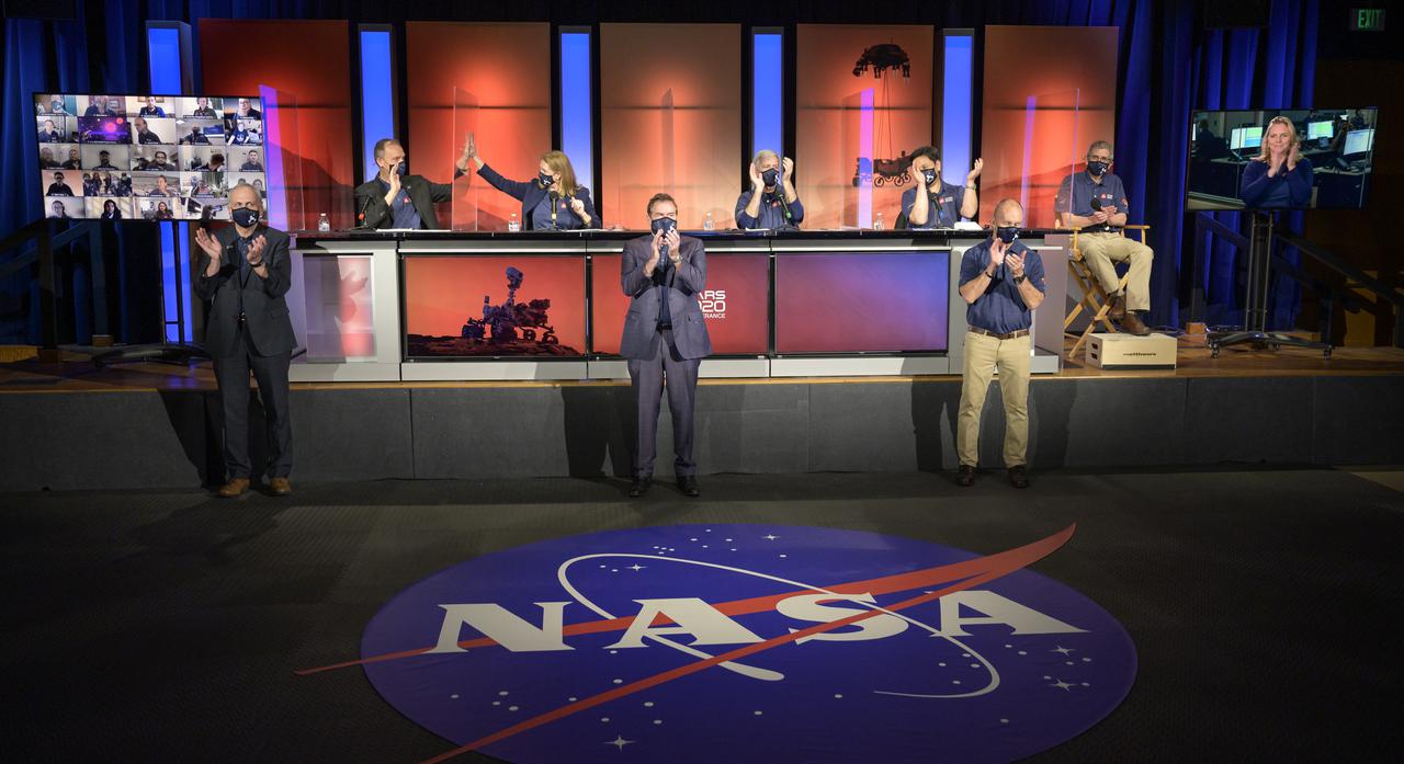 NASA Perseverance rover mission management and scientist celebrate a successful landing on Mars at the start of a post-landing update, Thursday, Feb. 18, 2021, at NASA's Jet Propulsion Laboratory in Pasadena, California. A key objective for Perseverance’s mission on Mars is astrobiology, including the search for signs of ancient microbial life. The rover will characterize the planet’s geology and past climate, pave the way for human exploration of the Red Planet, and be the first mission to collect and cache Martian rock and regolith. Photo Credit: (NASA/Bill Ingalls)