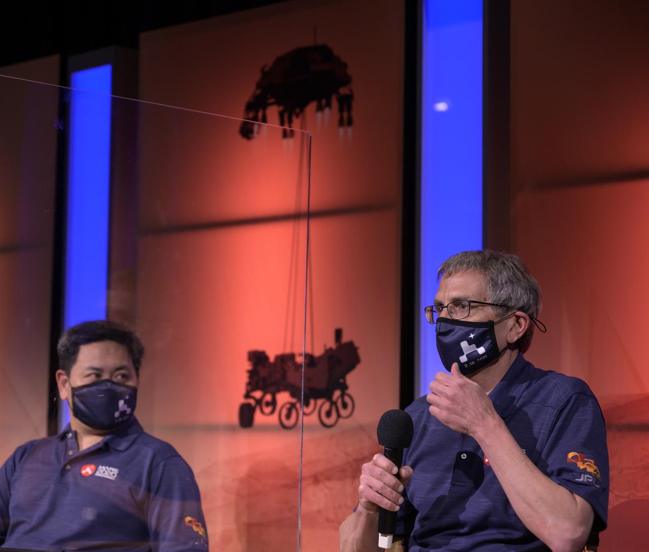 Perseverance project scientist, Caltech, Pasadena, California, Ken Farley, right, gives remarks during a NASA Perseverance rover mission post-landing update as Perseverance entry, descent, and landing phase lead Allen Chen looks on, Thursday, Feb. 18, 2021, at NASA's Jet Propulsion Laboratory in Pasadena, California. A key objective for Perseverance’s mission on Mars is astrobiology, including the search for signs of ancient microbial life. The rover will characterize the planet’s geology and past climate, pave the way for human exploration of the Red Planet, and be the first mission to collect and cache Martian rock and regolith. Photo Credit: (NASA/Bill Ingalls)