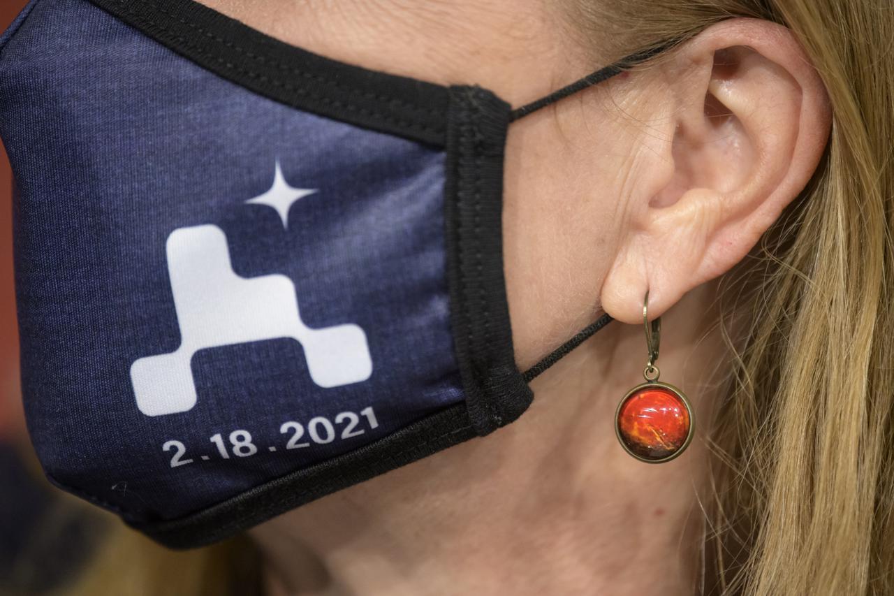 Mars earrings are seen on Director of NASA's Science Mission Directorate’s Planetary Science Division, Lori Glaze during a NASA Perseverance rover mission post-landing update, Thursday, Feb. 18, 2021, at NASA's Jet Propulsion Laboratory in Pasadena, California. A key objective for Perseverance’s mission on Mars is astrobiology, including the search for signs of ancient microbial life. The rover will characterize the planet’s geology and past climate, pave the way for human exploration of the Red Planet, and be the first mission to collect and cache Martian rock and regolith. Photo Credit: (NASA/Bill Ingalls)