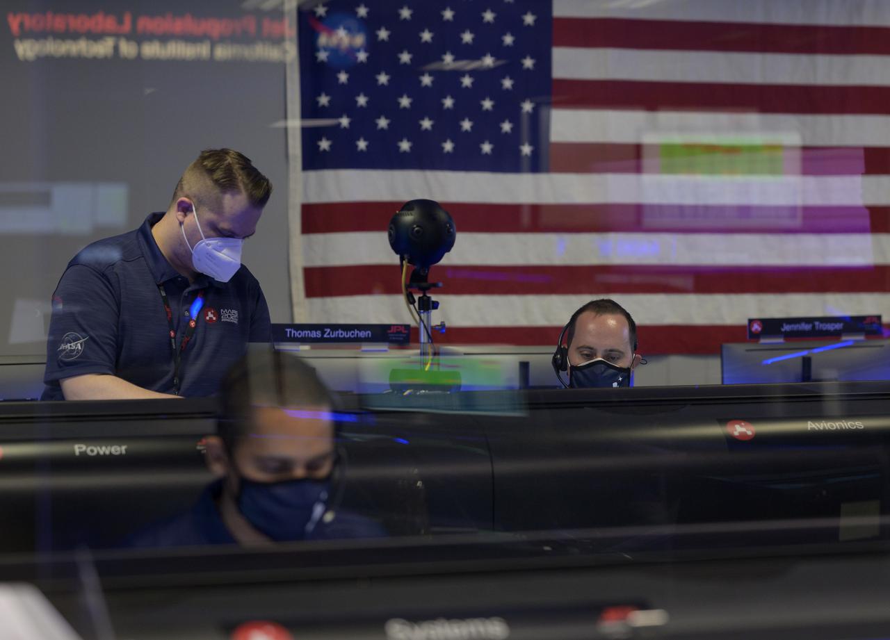 Members of NASA’s Perseverance Mars rover team study data on monitors in mission control, Thursday, Feb. 18, 2021, at NASA's Jet Propulsion Laboratory in Pasadena, California. A key objective for Perseverance’s mission on Mars is astrobiology, including the search for signs of ancient microbial life. The rover will characterize the planet’s geology and past climate, pave the way for human exploration of the Red Planet, and be the first mission to collect and cache Martian rock and regolith. Photo Credit: (NASA/Bill Ingalls)