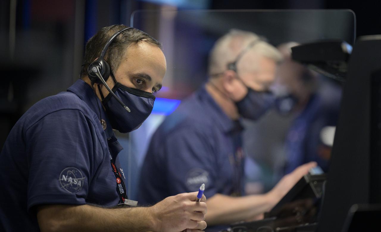 Perseverance flight director Magdy Bareh and other members of NASA’s Perseverance Mars rover team study data on monitors in mission control, Thursday, Feb. 18, 2021, at NASA's Jet Propulsion Laboratory in Pasadena, California. A key objective for Perseverance’s mission on Mars is astrobiology, including the search for signs of ancient microbial life. The rover will characterize the planet’s geology and past climate, pave the way for human exploration of the Red Planet, and be the first mission to collect and cache Martian rock and regolith. Photo Credit: (NASA/Bill Ingalls)