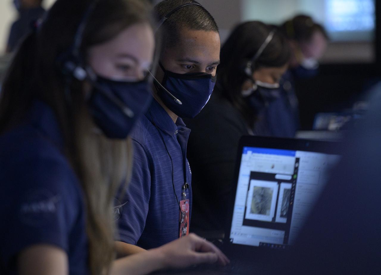 Members of NASA’s Perseverance Mars rover team study data on monitors in mission control, Thursday, Feb. 18, 2021, at NASA's Jet Propulsion Laboratory in Pasadena, California. A key objective for Perseverance’s mission on Mars is astrobiology, including the search for signs of ancient microbial life. The rover will characterize the planet’s geology and past climate, pave the way for human exploration of the Red Planet, and be the first mission to collect and cache Martian rock and regolith. Photo Credit: (NASA/Bill Ingalls)