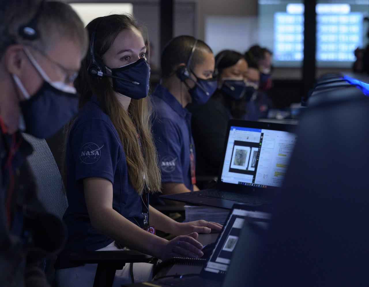 Members of NASA’s Perseverance Mars rover team study data on monitors in mission control, Thursday, Feb. 18, 2021, at NASA's Jet Propulsion Laboratory in Pasadena, California. A key objective for Perseverance’s mission on Mars is astrobiology, including the search for signs of ancient microbial life. The rover will characterize the planet’s geology and past climate, pave the way for human exploration of the Red Planet, and be the first mission to collect and cache Martian rock and regolith. Photo Credit: (NASA/Bill Ingalls)