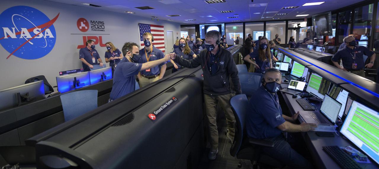 Members of NASA’s Perseverance rover team react in mission control after receiving confirmation the spacecraft successfully touched down on Mars, Thursday, Feb. 18, 2021, at NASA's Jet Propulsion Laboratory in Pasadena, California. A key objective for Perseverance’s mission on Mars is astrobiology, including the search for signs of ancient microbial life. The rover will characterize the planet’s geology and past climate, pave the way for human exploration of the Red Planet, and be the first mission to collect and cache Martian rock and regolith. Photo Credit: (NASA/Bill Ingalls)