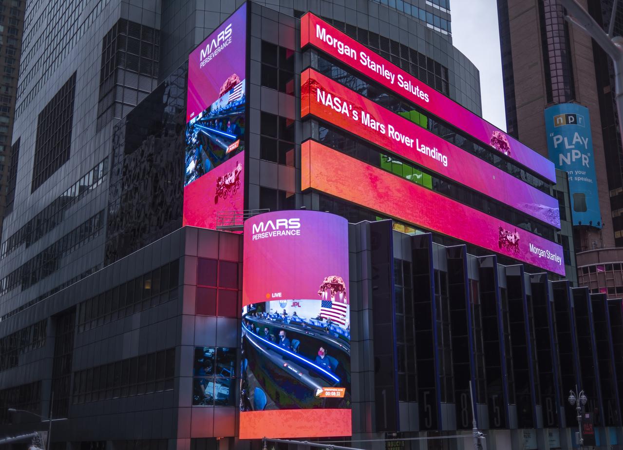 The live NASA TV broadcast from inside the Mission Support Area of NASA's Jet Propulsion Laboratory is seen on the Morgan Stanley video board as NASA's Perseverance rover begins its descent towards the surface of Mars, Thursday, Feb. 18, 2021 in New York City. A key objective for Perseverance’s mission on Mars is astrobiology, including the search for signs of ancient microbial life. The rover will characterize the planet’s geology and past climate, pave the way for human exploration of the Red Planet, and be the first mission to collect and cache Martian rock and regolith. Photo Credit: (NASA/Emma Howells)