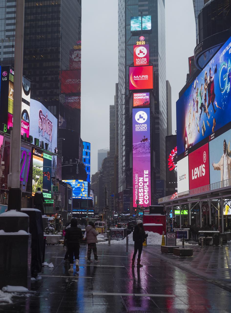 A NASA Mars Rover Landing banner is seen confirming the mission is complete on the One Times Square video board after NASA's Perseverance rover landed on the surface of Mars, Thursday, Feb. 18, 2021 in New York City. A key objective for Perseverance’s mission on Mars is astrobiology, including the search for signs of ancient microbial life. The rover will characterize the planet’s geology and past climate, pave the way for human exploration of the Red Planet, and be the first mission to collect and cache Martian rock and regolith. Photo Credit: (NASA/Emma Howells)