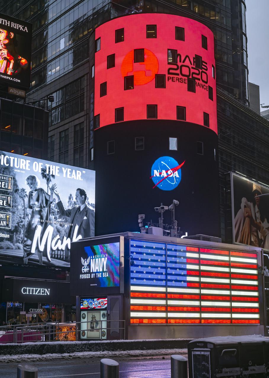 A Mars 2020 message is seen on the video board of the Nasdaq MarketSite after NASA's Perseverance rover landed on the surface of Mars, Thursday, Feb. 18, 2021 in New York City. A key objective for Perseverance’s mission on Mars is astrobiology, including the search for signs of ancient microbial life. The rover will characterize the planet’s geology and past climate, pave the way for human exploration of the Red Planet, and be the first mission to collect and cache Martian rock and regolith. Photo Credit: (NASA/Emma Howells)