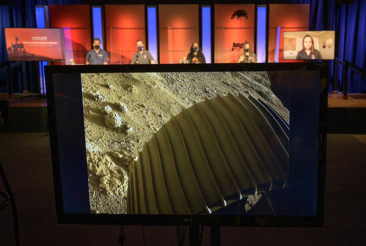 This high-resolution image showing one of the six wheels aboard NASA’s Perseverance Mars rover, which landed on Feb. 18, 2021, is shown during a NASA Perseverance rover initial surface checkout briefing, Friday Feb. 19, 2021, at NASA's Jet Propulsion Laboratory in Pasadena, California. The image was taken by one of Perseverance’s color Hazard Cameras (Hazcams.) A key objective for Perseverance’s mission on Mars is astrobiology, including the search for signs of ancient microbial life. The rover will characterize the planet’s geology and past climate, pave the way for human exploration of the Red Planet, and be the first mission to collect and cache Martian rock and regolith. Photo Credit: (NASA/Bill Ingalls)