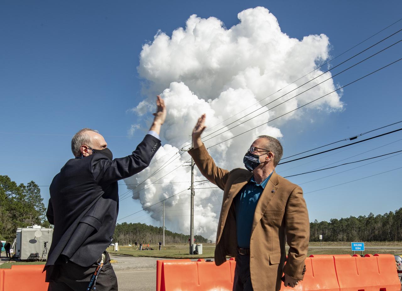 Acting NASA Administrator Steve Jurczyk, left, and Rick Gilbrech, director of NASA's Stennis Space Center, right, high five following a second hot fire test of the core stage for the first flight of NASA’s Space Launch System rocket in the B-2 Test Stand, Thursday, March 18, 2021, at NASA’s Stennis Space Center near Bay St. Louis, Mississippi. The four RS-25 engines fired for the full-duration of 8 minutes during the test and generated 1.6 million pounds of thrust. The hot fire test is the final stage of the Green Run test series, a comprehensive assessment of the Space Launch System’s core stage prior to launching the Artemis I mission to the Moon.  Photo Credit: (NASA/Robert Markowitz)