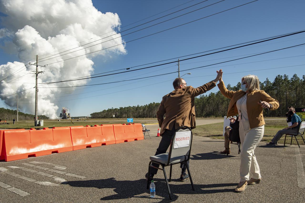 Rick Gilbrech, director of NASA's Stennis Space Center, left, and Jody Singer, director of NASA's Marshall Space Flight Center, right, high five following a second hot fire test of the core stage for the first flight of NASA’s Space Launch System rocket in the B-2 Test Stand, Thursday, March 18, 2021, at NASA’s Stennis Space Center near Bay St. Louis, Mississippi. The four RS-25 engines fired for the full-duration of 8 minutes during the test and generated 1.6 million pounds of thrust. The hot fire test is the final stage of the Green Run test series, a comprehensive assessment of the Space Launch System’s core stage prior to launching the Artemis I mission to the Moon.  Photo Credit: (NASA/Robert Markowitz)