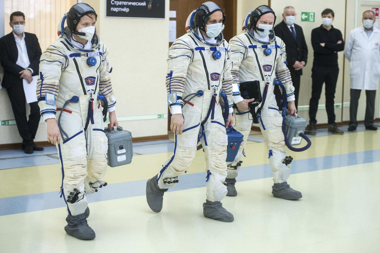 Expedition 65 backup crew members NASA astronaut Anne McClain, left, Russian cosmonaut Anton Shkaplerov of Roscosmos, center, and Russian cosmonaut Oleg Artemyev of Roscosmos arrive for Soyuz qualification exams Monday, March 22, 2021, at the Gagarin Cosmonaut Training Center (GCTC) in Star City, Russia, in advance of the Expedition 65 launch April 9 from Baikonur Cosmodrome in Kazakhstan to the International Space Station. Photo Credit: (NASA/GCTC/Andrey Shelepin)