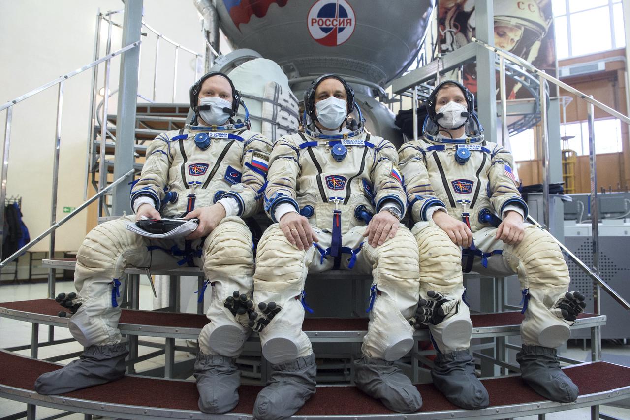 Expedition 65 backup crew members Russian cosmonaut Oleg Artemyev of Roscosmos, left, Russian cosmonaut Anton Shkaplerov of Roscosmos, center, and NASA astronaut Anne McClain, pose for a photo during Soyuz qualification exams Monday, March 22, 2021, at the Gagarin Cosmonaut Training Center (GCTC) in Star City, Russia, in advance of the Expedition 65 launch April 9 from Baikonur Cosmodrome in Kazakhstan to the International Space Station. Photo Credit: (NASA/GCTC/Andrey Shelepin)