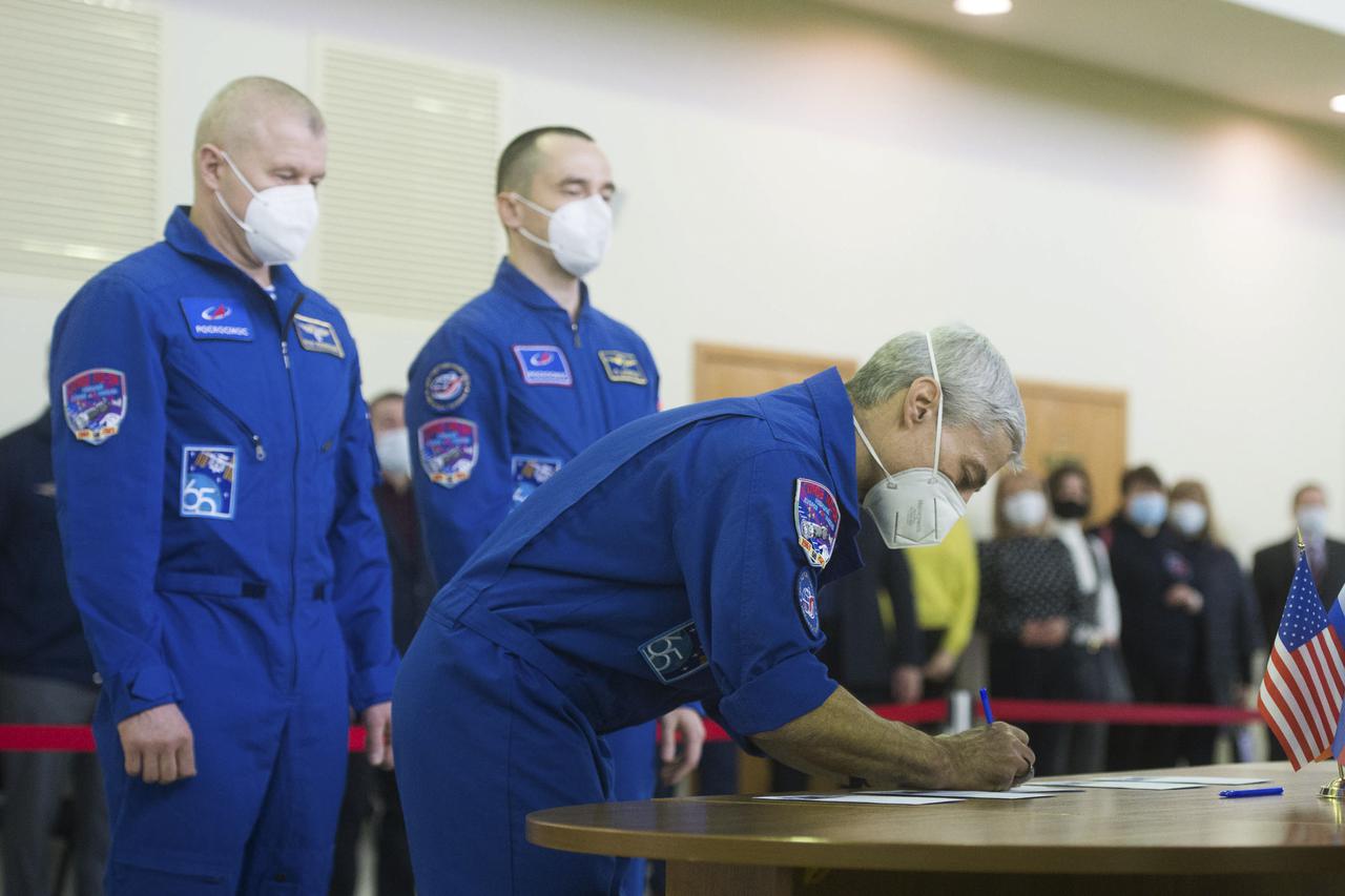 Expedition 65 crew member NASA astronaut Mark Vande Hei, signs in for Soyuz qualification exams while crew mates Russian cosmonaut Oleg Novitskiy of Roscosmos, left, and Russian cosmonaut Pyotr Dubrov of Roscosmos look on, Monday, March 22, 2021, at the Gagarin Cosmonaut Training Center (GCTC) in Star City, Russia, in advance of their scheduled launch April 9 from Baikonur Cosmodrome in Kazakhstan to the International Space Station. Photo Credit: (NASA/GCTC/Andrey Shelepin)