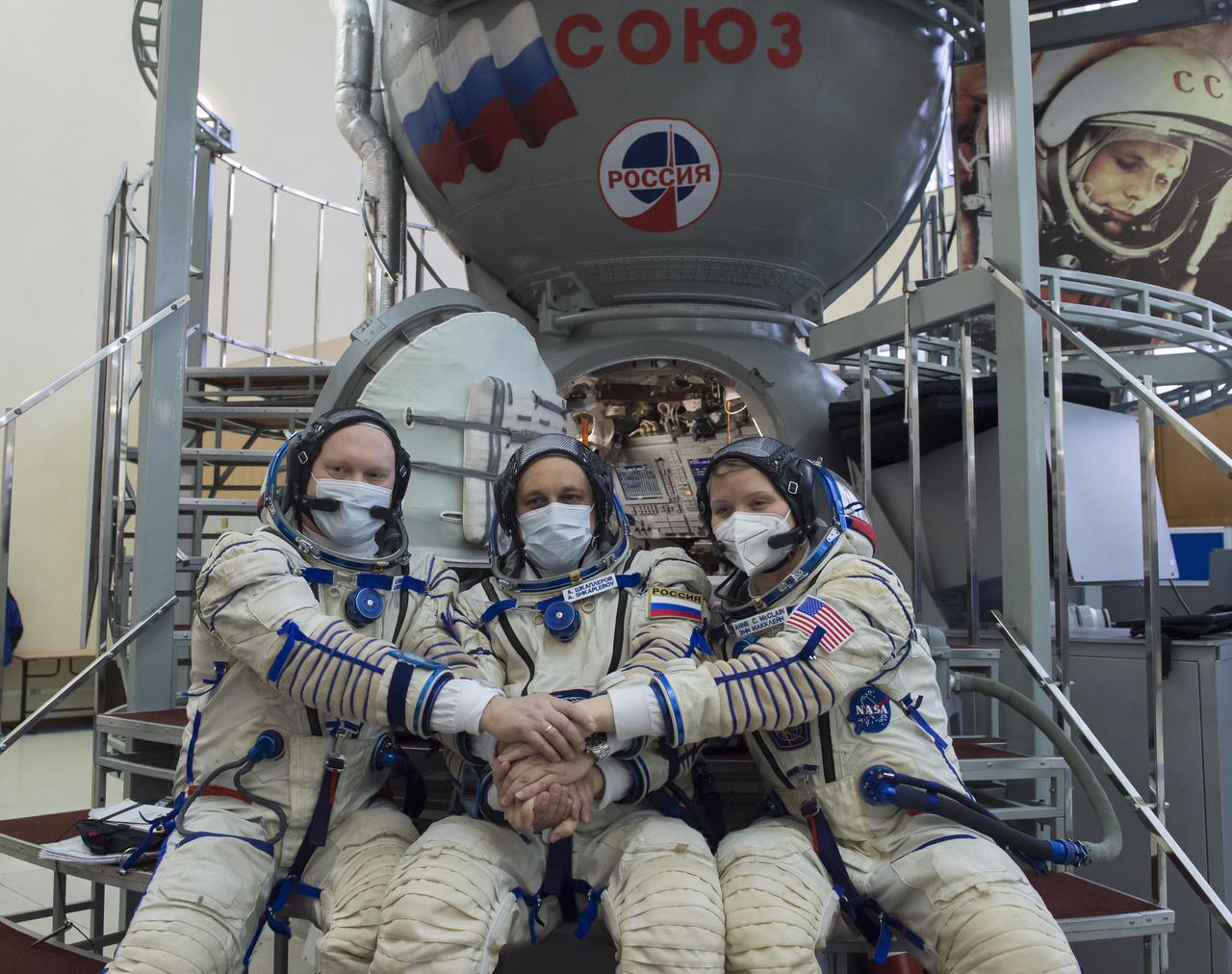 Expedition 65 backup crew members Russian cosmonaut Oleg Artemyev of Roscosmos, left, Russian cosmonaut Anton Shkaplerov of Roscosmos, center, and NASA astronaut Anne McClain, pose for a photo during Soyuz qualification exams Monday, March 22, 2021 at the Gagarin Cosmonaut Training Center (GCTC) in Star City, Russia, in advance of the Expedition 65 launch April 9 from Baikonur Cosmodrome in Kazakhstan to the International Space Station. Photo Credit: (NASA/GCTC/Irina Spector)