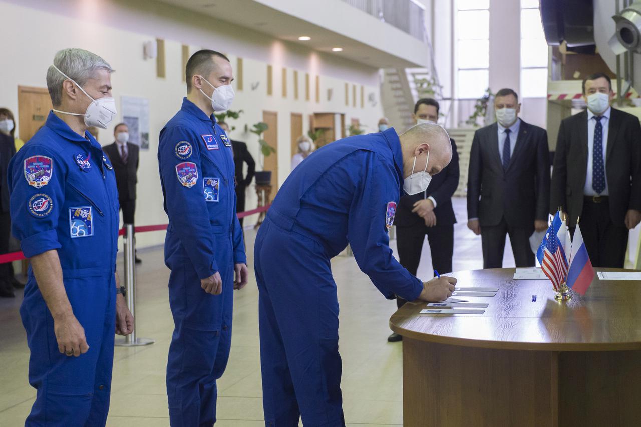 Expedition 65 crew member Russian cosmonaut Oleg Novitskiy of Roscosmos, signs in for Soyuz qualification exams while crew mates Mark Vande Hei of NASA, left, and Pyotr Dubrov of Roscosmos look on, Monday, March 22, 2021 at the Gagarin Cosmonaut Training Center (GCTC) in Star City, Russia, in advance of their scheduled launch April 9 from Baikonur Cosmodrome in Kazakhstan to the International Space Station. Photo Credit: (NASA/GCTC/Irina Spector)
