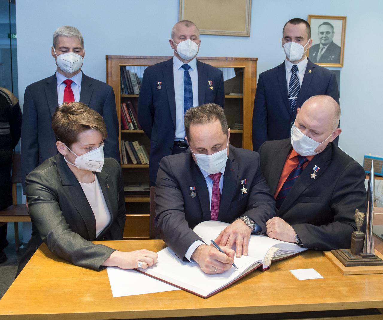 Expedition 65 backup crew member, Anton Shkaplerov of Roscosmos signs a guest book at the "Memorial working study of Yuri Gagarin" at the Gagarin Cosmonaut Training Center (GCTC), as his crew mates watch, Wednesday, March 24, 2021 in Star City, Russia. The memorial study represents Gagarin's working study in the way it was abandoned by Gagarin on March 27, 1968 before leaving for the airfield for training flight that became his last. Photo Credit: (NASA/GCTC/Irina Spector)