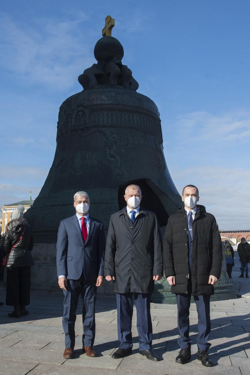 Expedition 65 prime crew members, NASA astronaut Mark Vande Hei, left, Russian cosmonaut Oleg Novitskiy of Roscosmos, center, and Russian cosmonaut Pyotr Dubrov of Roscosmos, right, pose for a photo in front of the Tsar Bell in Red Square after laying flowers at the site where Russian space icons are interred as part of traditional pre-launch ceremonies, Wednesday, March 24, 2021 in Moscow. Photo Credit: (NASA/GCTC/Andrey Shelepin)