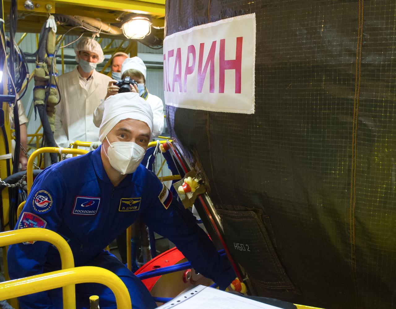 Expedition 65 prime crew member Russian cosmonaut Pyotr Dubrov of Roscosmos is seen heading inside the Soyuz MS-18 spacecraft during a fit check to prepare for launch with fellow cosmonaut Oleg Novitskiy of Roscosmos, and NASA astronaut Mark Vande Hei, Saturday, March 27, 2021 at the Baikonur Cosmodrome in Kazakhstan. They are scheduled to launch on a Soyuz rocket April 9. Photo Credit: (NASA/GCTC/Irina Spector)