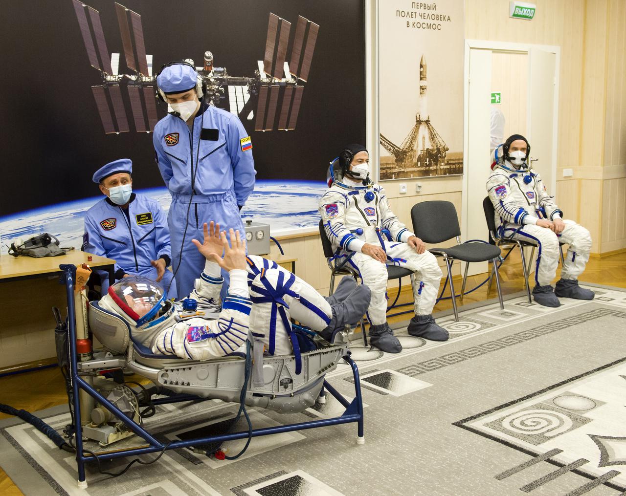 Expedition 65 prime crew member Oleg Novitskiy of Roscosmos, left, has his Sokol suit pressure checked while fellow crew mates, NASA astronaut Mark Vande Hei, center, and Russian cosmonaut Pyotr Dubrov of Roscosmos look on, during a fit check to prepare for launch, Saturday, March 27, 2021 at the Baikonur Cosmodrome in Kazakhstan. They are scheduled to launch on a Soyuz rocket April 9. Photo Credit: (NASA/GCTC/Irina Spector)
