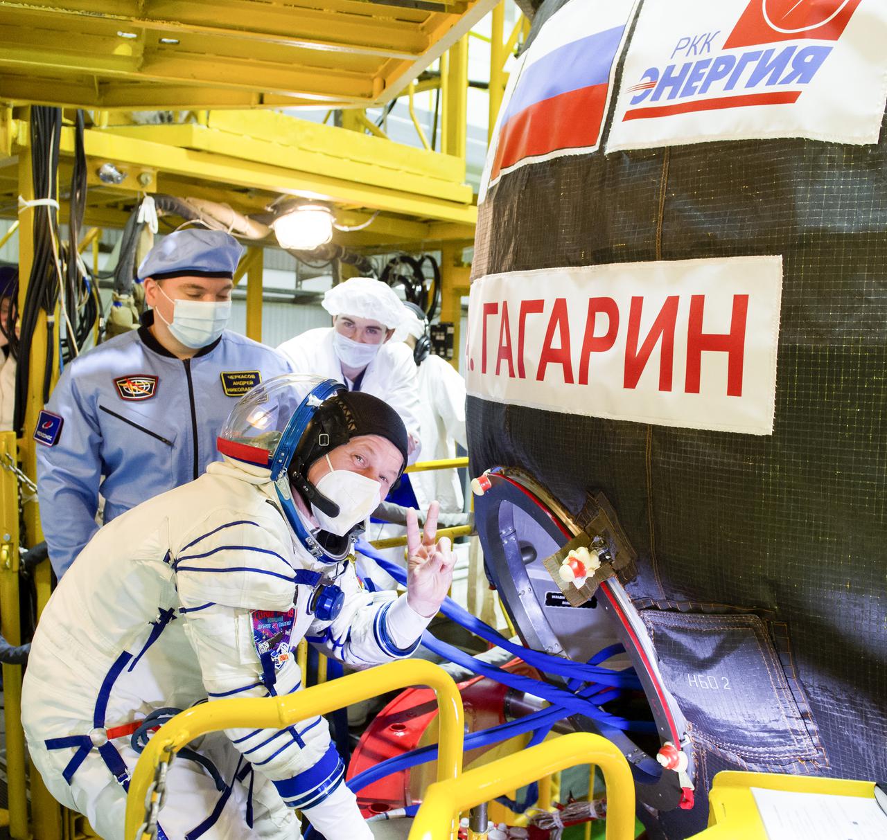 Expedition 65 prime crew member Russian cosmonaut Oleg Novitskiy of Roscosmos gestures as he heads inside the Soyuz MS-18 spacecraft during a fit check to prepare for launch with fellow Russian cosmonaut Pyotr Dubrov of Roscosmos, and NASA astronaut Mark Vande Hei, Saturday, March 27, 2021 at the Baikonur Cosmodrome in Kazakhstan. They are scheduled to launch on a Soyuz rocket April 9. Photo Credit: (NASA/GCTC/Irina Spector)