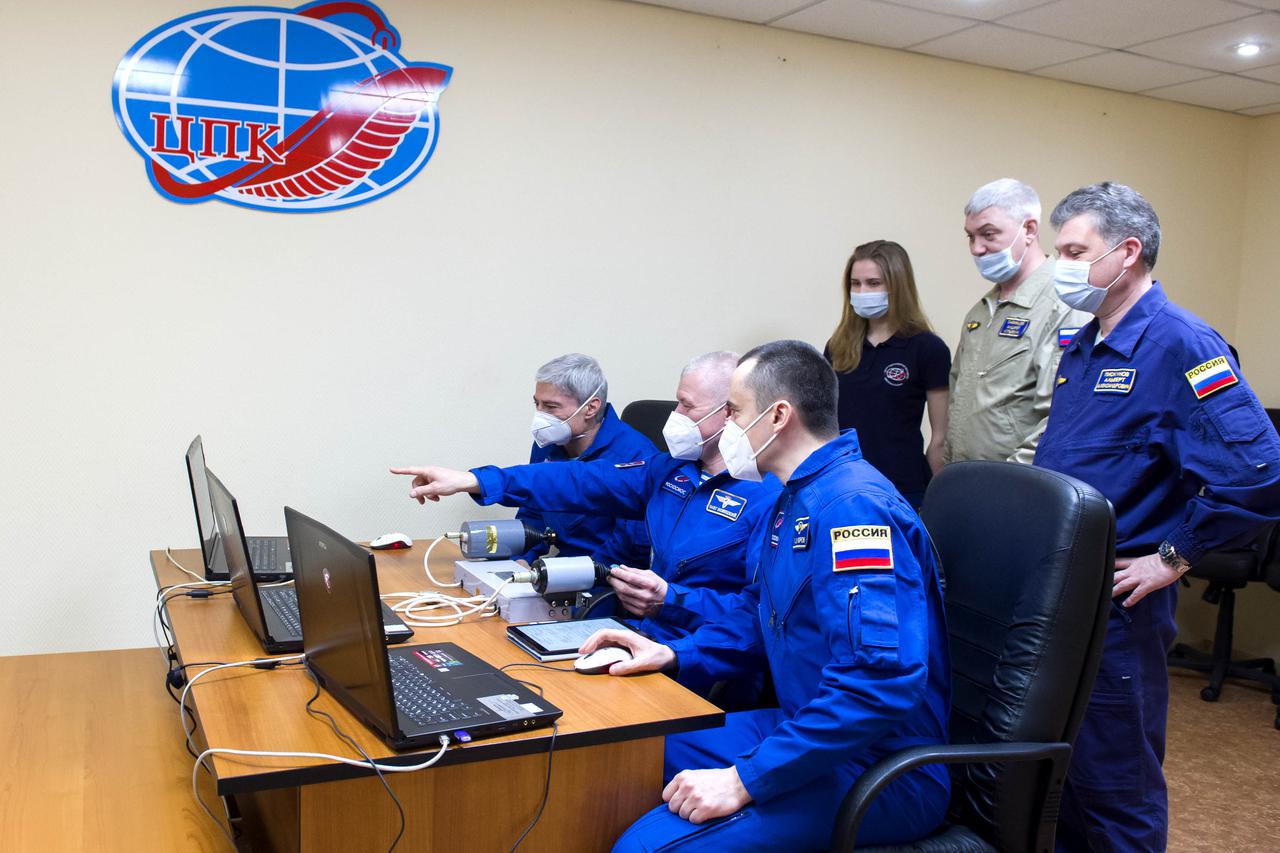 Expedition 65 prime crew members NASA astronaut Mark Vande Hei, left, and Russian cosmonauts Oleg Novitskiy, center, and Pyotr Dubrov, right, of Roscosmos practice rendezvous techniques on a laptop simulator, Saturday, April 3, 2021, at the Cosmonaut Hotel in Baikonur, Kazakhstan. They are scheduled to launch to the International Space Station aboard the Soyuz MS-18 spacecraft on April 9. Photo Credit: (NASA/GCTC/Irina Spector)