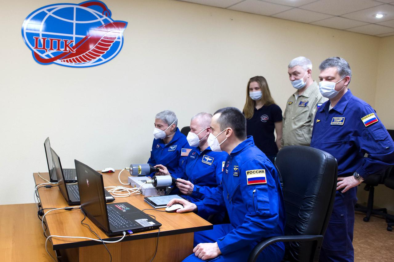 Expedition 65 prime crew members NASA astronaut Mark Vande Hei, left, and Russian cosmonauts Oleg Novitskiy, center, and Pyotr Dubrov, right, of Roscosmos practice rendezvous techniques on a laptop simulator, Saturday, April 3, 2021, at the Cosmonaut Hotel in Baikonur, Kazakhstan. They are scheduled to launch to the International Space Station aboard the Soyuz MS-18 spacecraft on April 9. Photo Credit: (NASA/GCTC/Irina Spector)