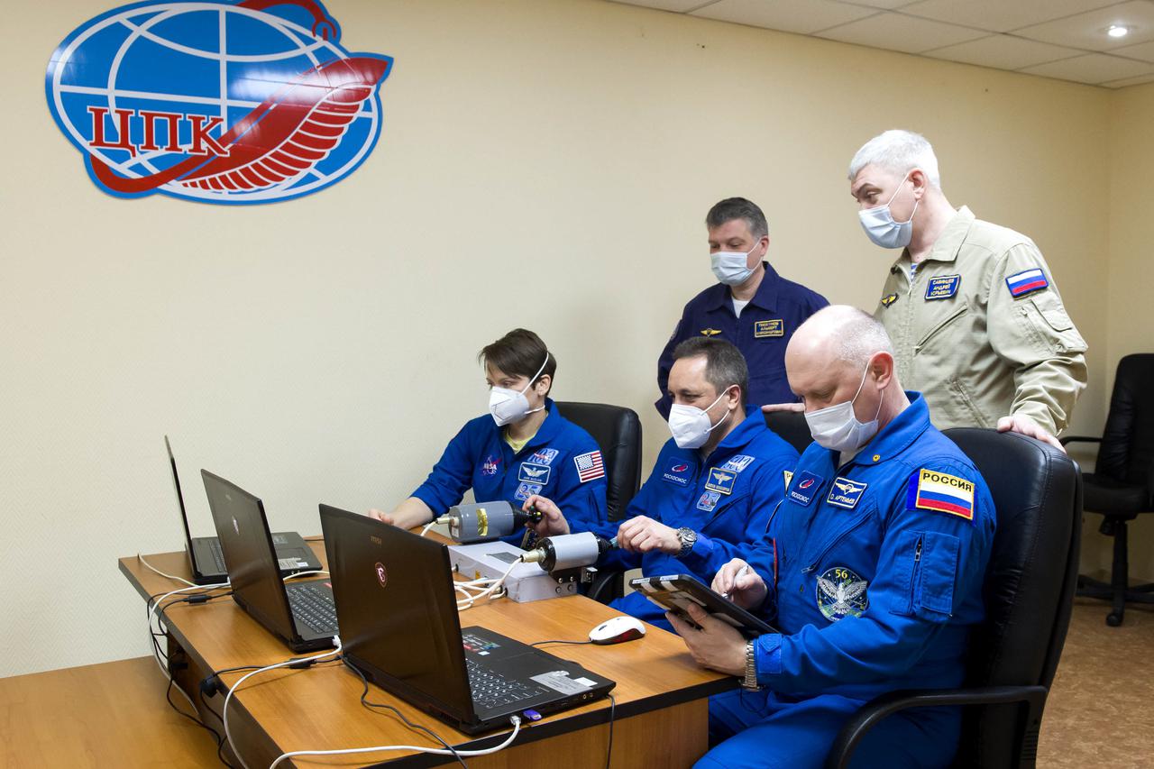 Expedition 65 backup crew members NASA astronaut Anne McClain, left, and Russian cosmonauts Anton Shkaplerov, center, and Oleg Artemyev, right, of Roscosmos practice rendezvous techniques on a laptop simulator, Saturday, April 3, 2021, in Baikonur, Kazakhstan. The prime crew is scheduled to launch to the International Space Station aboard the Soyuz MS-18 spacecraft on April 9. Photo Credit: (NASA/GCTC/Irina Spector)