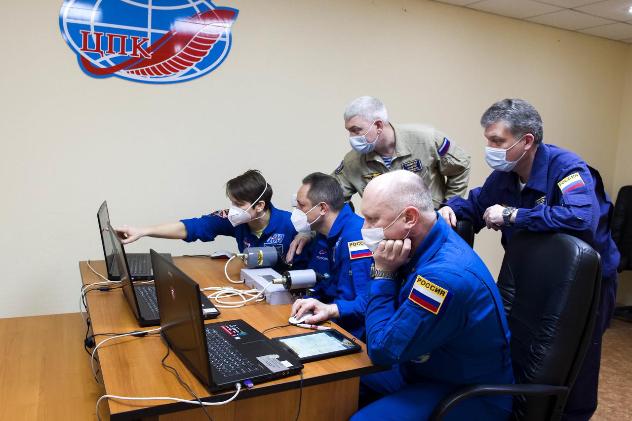 Expedition 65 backup crew members NASA astronaut Anne McClain, left, and Russian cosmonauts Anton Shkaplerov, center, and Oleg Artemyev, right, of Roscosmos practice rendezvous techniques on a laptop simulator, Saturday, April 3, 2021, in Baikonur, Kazakhstan. The prime crew is scheduled to launch to the International Space Station aboard the Soyuz MS-18 spacecraft on April 9. Photo Credit: (NASA/GCTC/Irina Spector)