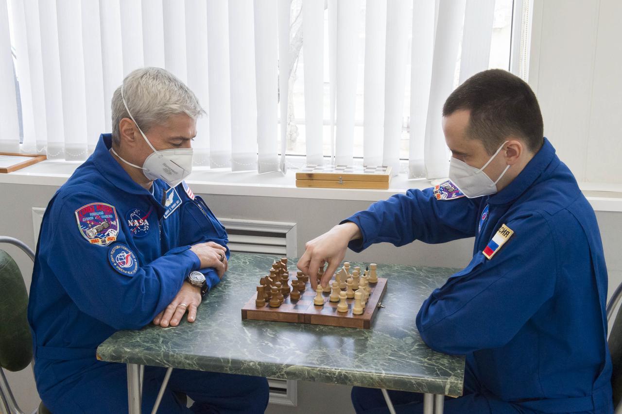 Expedition 65 prime crew members NASA astronaut Mark Vande Hei, left, plays a game of chess with his crew mate Russian cosmonaut Pyotr Dubrov of Roscosmos Saturday, April 3, 2021, at the Cosmonaut Hotel in Baikonur, Kazakhstan. Vande Hei, Dubrov and Oleg Novitskiy of Roscosmos are scheduled to launch to the International Space Station aboard the Soyuz MS-18 spacecraft on April 9. Photo Credit: (NASA/GCTC/Irina Spector)