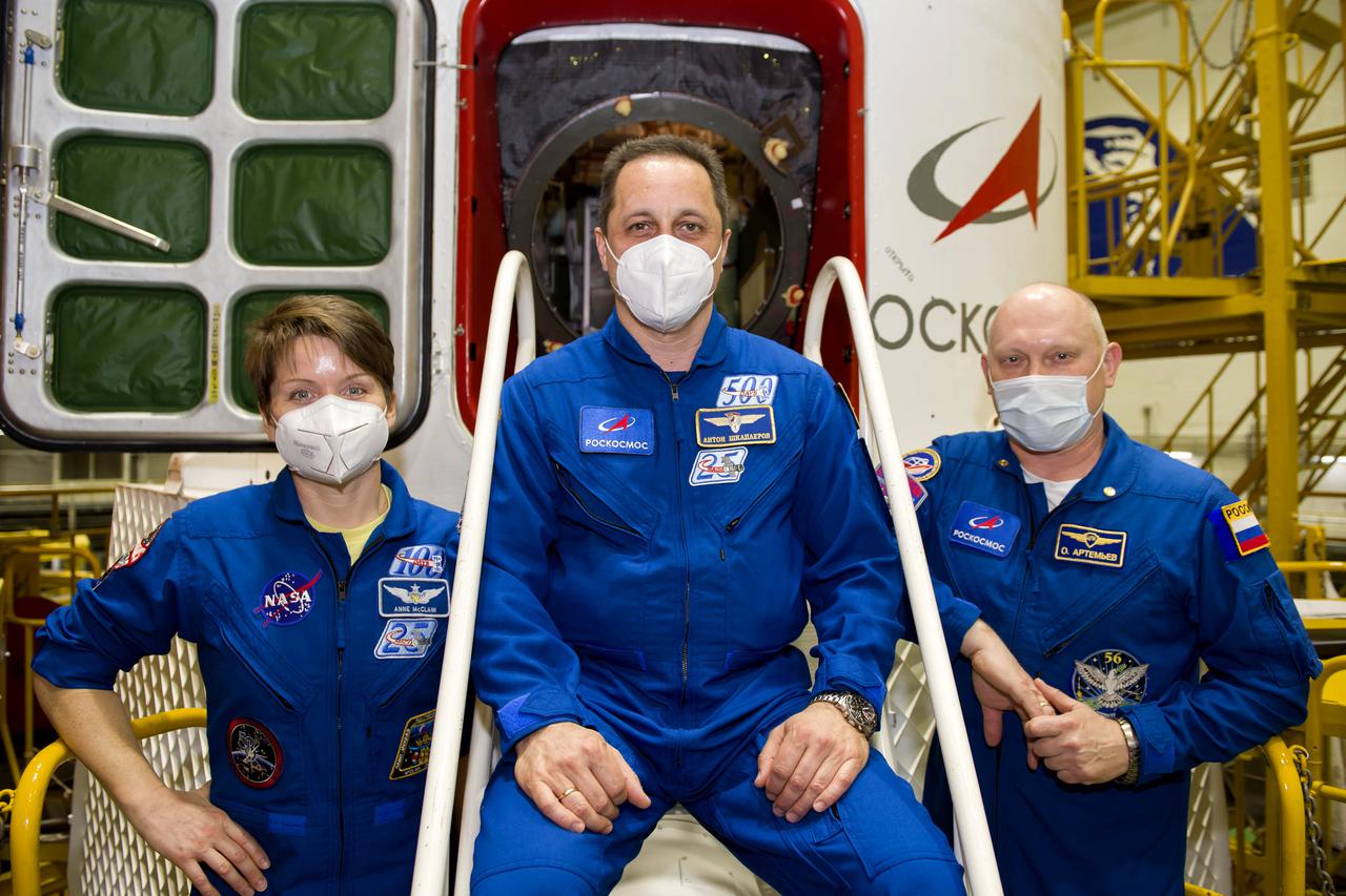 Expedition 65 backup crew members NASA astronaut Anne McClain, left, and Russian cosmonauts Anton Shkaplerov, center, and Oleg Artemyev of Roscosmos, pose for a photo during a final fit check, Sunday, April 4, 2021 at the Baikonur Cosmodrome in Kazakhstan. The prime crew is scheduled to launch to the International Space Station on a Soyuz rocket April 9. Photo Credit: (NASA/GCTC/Irina Spector)