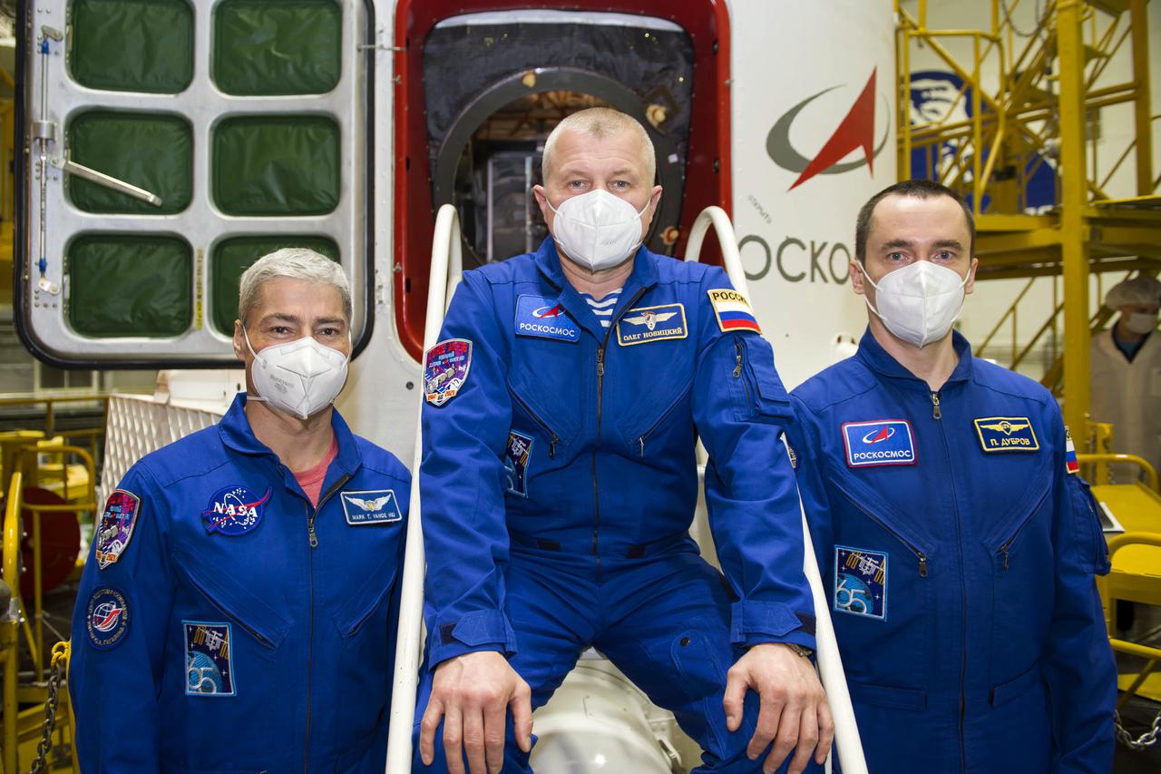 Expedition 65 prime crew members NASA astronaut Mark Vande Hei, left, and Russian cosmonauts Oleg Novitskiy, center, and Pyotr Dubrov of Roscosmos pose for a photo outside the Soyuz MS-18 spacecraft during the final fit check to prepare for launch Sunday, April 4, 2021 at the Baikonur Cosmodrome in Kazakhstan. The trio are scheduled to launch to the International Space Station on a Soyuz rocket April 9. Photo Credit: (NASA/GCTC/Irina Spector)