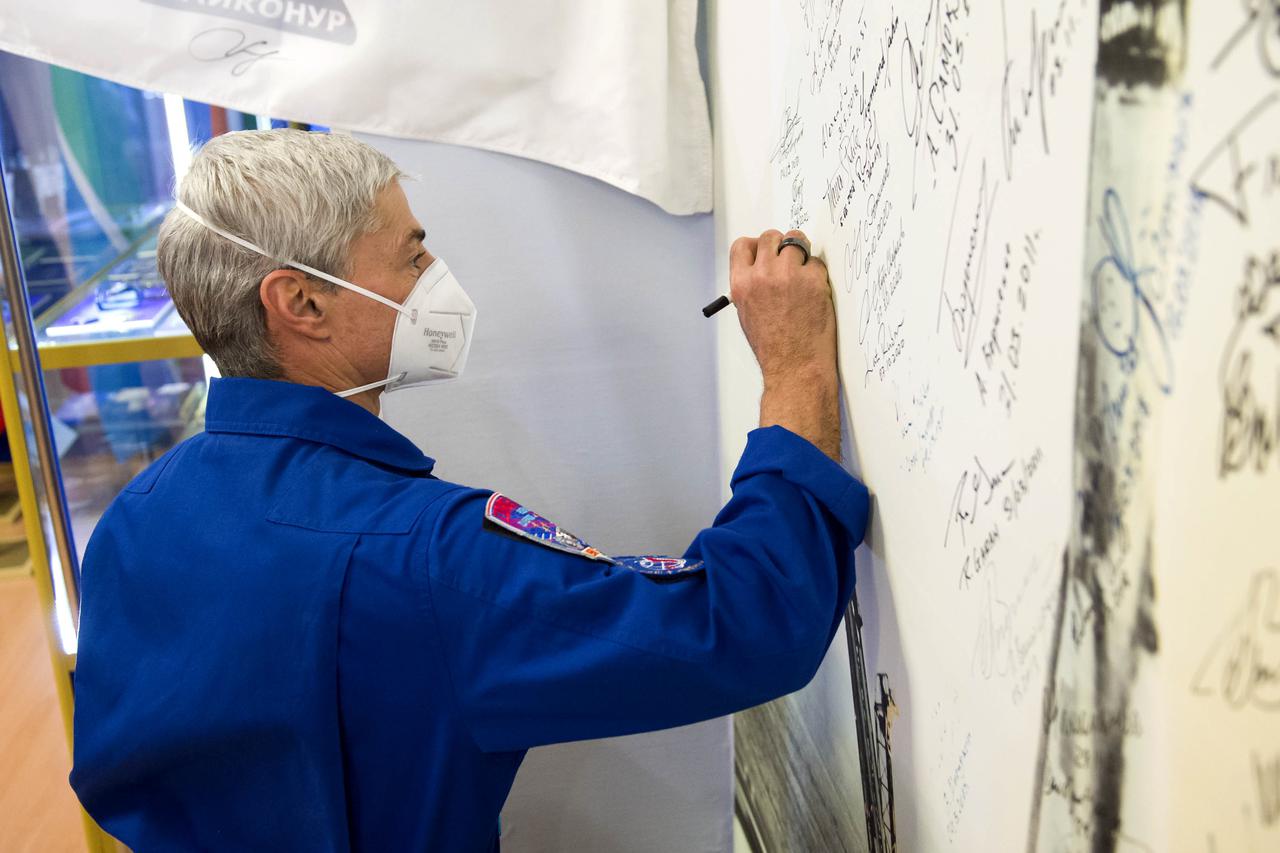 Expedition 65 prime crew member NASA astronaut Mark Vande Hei, signs his name to a wall mural bearing the picture of a Soyuz launch at the Baikonur Cosmodrome Museum, Sunday, April 4, 2021 at the Baikonur Cosmodrome in Kazakhstan. Vande Hei, Oleg Novitskiy and Pyotr Dubrov of Roscosmos are scheduled to launch to the International Space Station aboard the Soyuz MS-18 spacecraft on April 9. Photo Credit: (NASA/GCTC/Irina Spector)