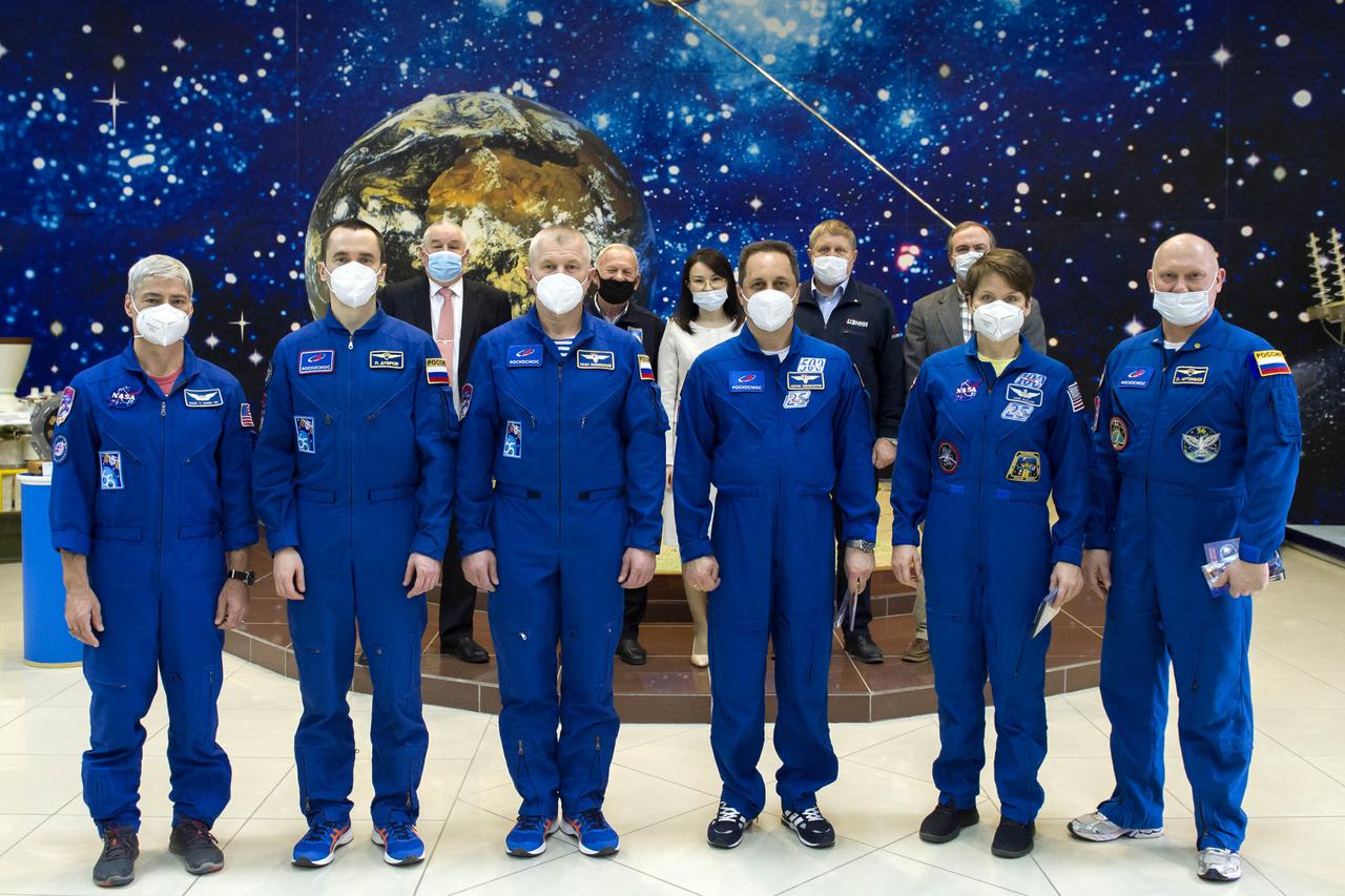 From left to right, Expedition 65 prime crew members NASA astronaut Mark Vande Hei, and Russian cosmonauts Pyotr Dubrov, and Oleg Novitskiy of Roscosmos, pose for a photo with backup crew members Russian cosmonaut Anton Shkaplerov of Roscosmos, NASA astronaut Anne McClain, and Oleg Artemyev of Roscosmos, after the final Soyuz MS-18 spacecraft fit check, Sunday, April 4, 2021 at the Baikonur Cosmodrome in Kazakhstan. The prime crew is scheduled to launch to the International Space Station on a Soyuz rocket April 9. Photo Credit: (NASA/GCTC/Irina Spector)