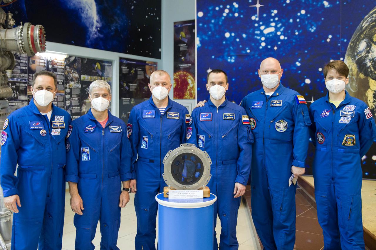 From left to right, Expedition 65 backup crew member Anton Shkaplerov of Roscosmos, Expedition 65 prime crew members, NASA astronaut Mark Vande Hei, and Russian cosmonauts Oleg Novitskiy, and Pyotr Dubrov of Roscosmos, backup crew members Russian cosmonaut Oleg Artemyev of Roscosmos, and NASA astronaut Anne McClain, pose for a photo with an optical device used to manually monitor docking on the Soyuz spacecraft at the Baikonur Cosmodrome Museum, Sunday, April 4, 2021 in Baikonur, Kazakhstan. The prime crew is scheduled to launch to the International Space Station aboard the Soyuz MS-18 spacecraft on April 9. Photo Credit: (NASA/GCTC/Irina Spector)