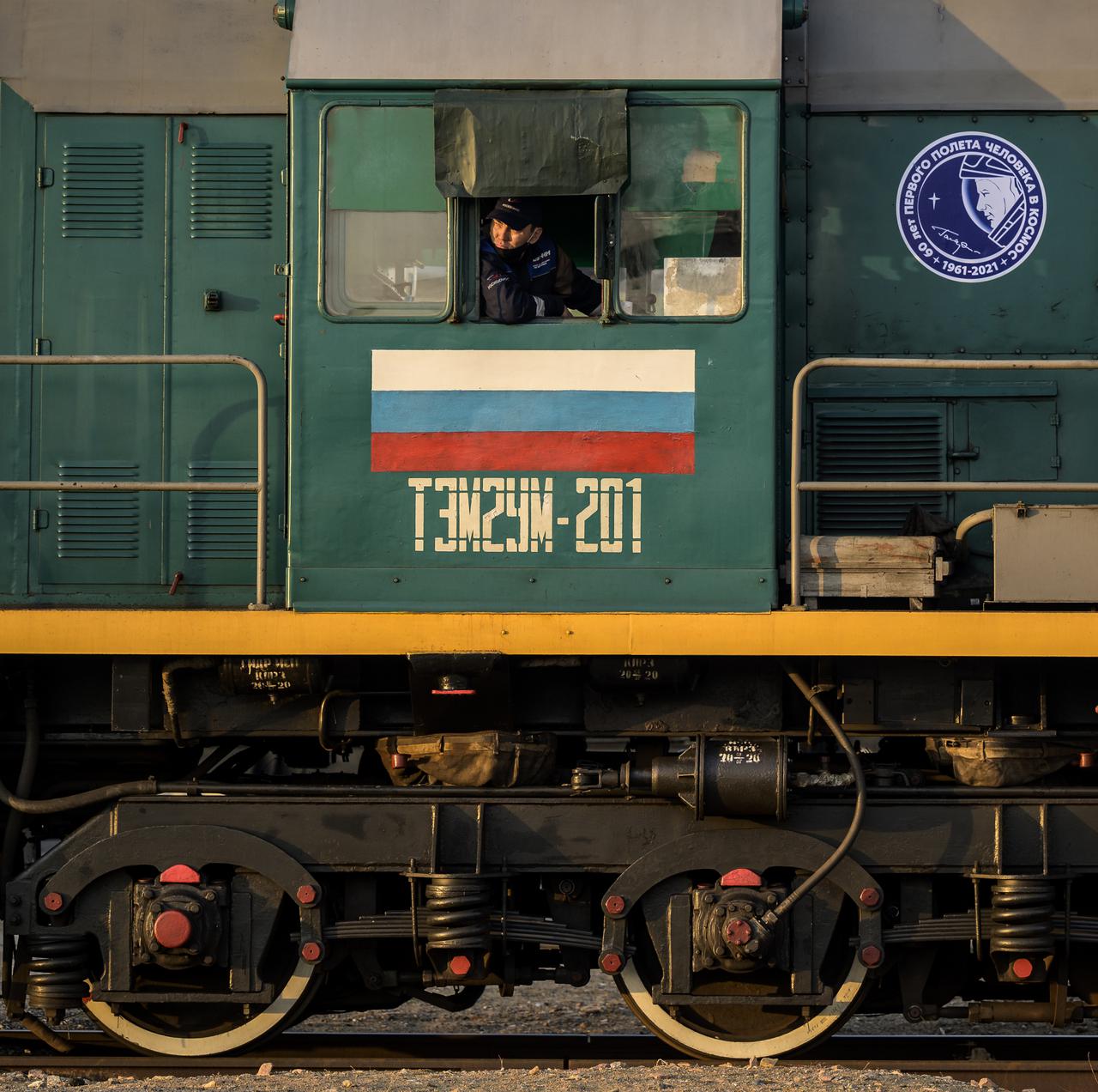 A locomotive engineer waits in advance of the Soyuz rocket being rolled out by train to the launch pad at Site 31, Tuesday, April 6, 2021, at the Baikonur Cosmodrome in Kazakhstan. Expedition 65 NASA astronaut Mark Vande Hei, Roscosmos cosmonauts Pyotr Dubrov and Oleg Novitskiy are scheduled to launch aboard their Soyuz MS-18 spacecraft on April 9. Photo Credit: (NASA/Bill Ingalls)