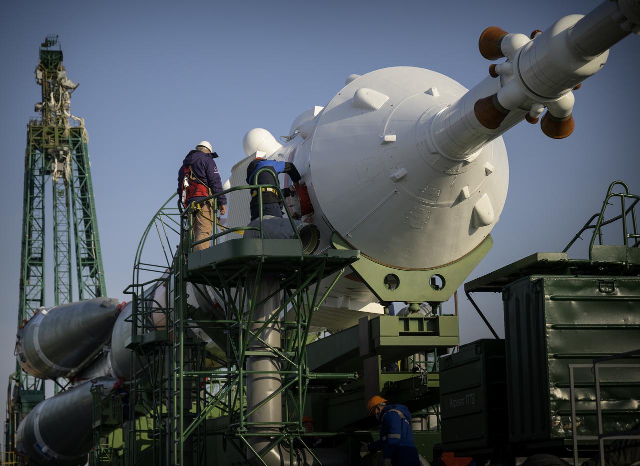 Technicians work on the Soyuz rocket after it is rolled out by train to the launch pad at Site 31, Tuesday, April 6, 2021, at the Baikonur Cosmodrome in Kazakhstan. Expedition 65 NASA astronaut Mark Vande Hei, Roscosmos cosmonauts Pyotr Dubrov and Oleg Novitskiy are scheduled to launch aboard their Soyuz MS-18 spacecraft on April 9. Photo Credit: (NASA/Bill Ingalls)