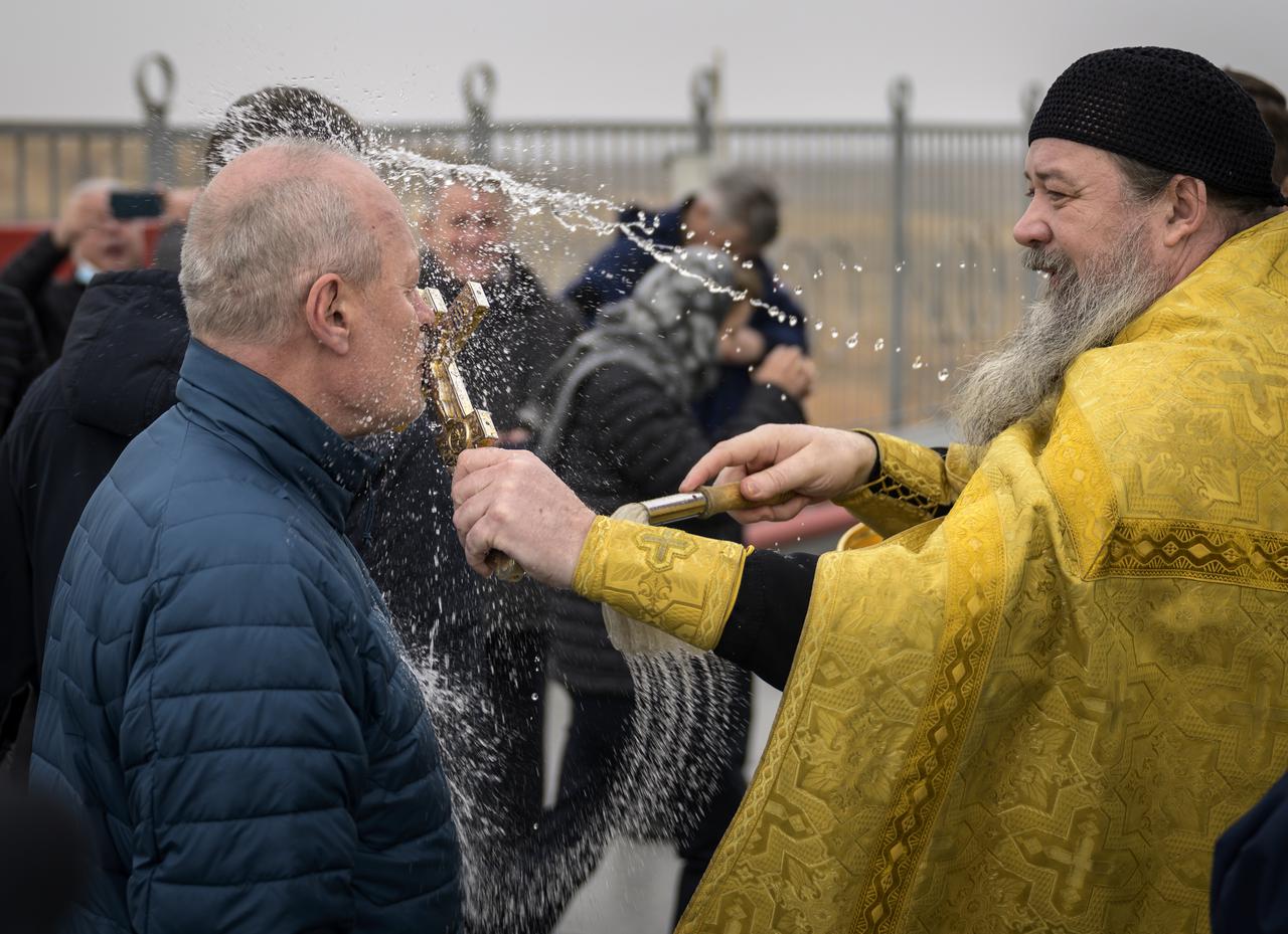 Russian Orthodox Priest Father Sergei blesses mission support personnel at the Baikonur Cosmodrome launch pad after having blessed the Soyuz rocket, Thursday, April 8, 2021, in Kazakhstan. Expedition 65 NASA astronaut Mark Vande Hei, Roscosmos cosmonauts Pyotr Dubrov and Oleg Novitskiy are scheduled to launch aboard their Soyuz MS-18 spacecraft on April 9.  Photo Credit: (NASA/Bill Ingalls)