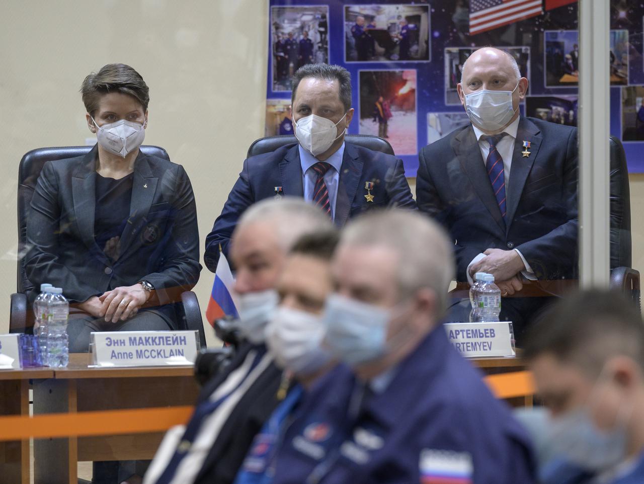 Expedition 65 backup crew members NASA astronaut Anne McClain, left, and Russian cosmonauts Anton Shkaplerov of Roscosmos, and Oleg Artemyev of Roscosmos, right, are seen during the State Commission meeting to approve the Soyuz launch of Expedition 65 to the International Space Station, Thursday, April 8, 2021 at the Cosmonaut Hotel in Baikonur, Kazakhstan.  Expedition 65 NASA astronaut Mark Vande Hei, Roscosmos cosmonauts Pyotr Dubrov and Oleg Novitskiy, are scheduled to launch to the International Space Station aboard the Soyuz MS-18 spacecraft on April 9. Photo Credit: (NASA/Bill Ingalls)