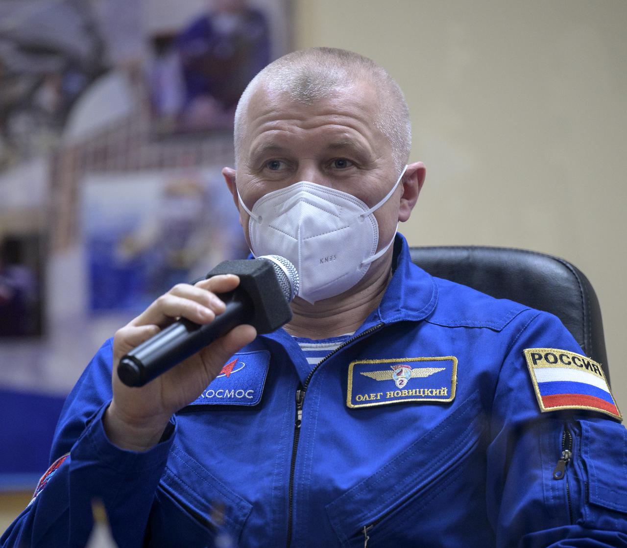 Expedition 65 Russian cosmonaut Oleg Novitskiy is seen in quarantine, behind glass, during a press conference, Thursday, April 8, 2021 a the Cosmonaut Hotel in Baikonur, Kazakhstan. Expedition 65 NASA astronaut Mark Vande Hei, Roscosmos cosmonauts Pyotr Dubrov and Novitskiy are scheduled to launch to the International Space Station aboard the Soyuz MS-18 spacecraft on April 9.  Photo Credit: (NASA/Bill Ingalls)