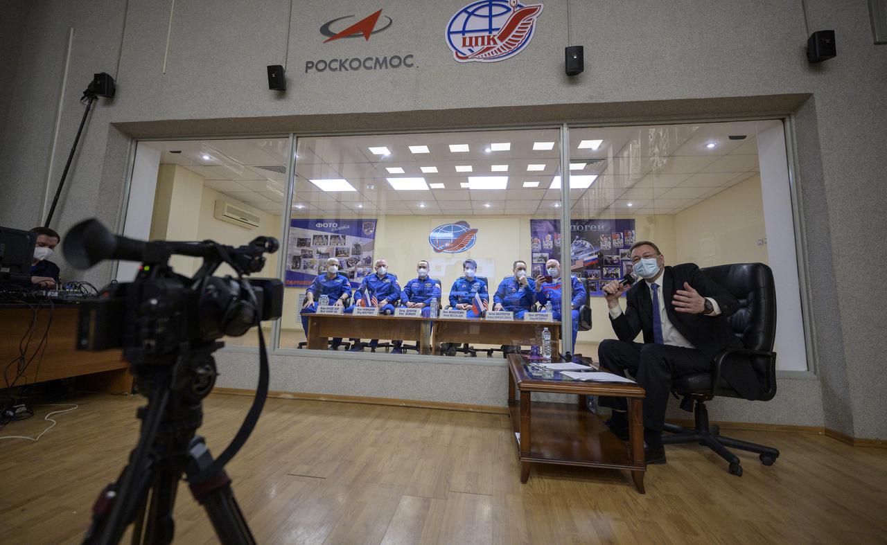 Expedition 65 NASA astronaut Mark Vande Hei, left, Roscosmos cosmonauts Oleg Novitskiy and Pyotr Dubrov, along with backup crew members Anne McClain of NASA, and Roscosmos cosmonauts Anton Shkaplerov and Oleg Artemyev, right, are seen in quarantine, behind glass, during a press conference, Thursday, April 8, 2021 a the Cosmonaut Hotel in Baikonur, Kazakhstan. The prime crew is scheduled to launch to the International Space Station aboard the Soyuz MS-18 spacecraft on April 9.  Photo Credit: (NASA/Bill Ingalls)