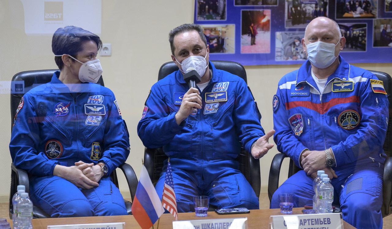 Expedition 65 backup crew members NASA astronaut Anne McClain, left, and Russian cosmonauts Anton Shkaplerov of Roscosmos, and Oleg Artemyev of Roscosmos, right, are seen in quarantine, behind glass, during a press conference, Thursday, April 8, 2021 a the Cosmonaut Hotel in Baikonur, Kazakhstan. Expedition 65 NASA astronaut Mark Vande Hei,  Roscosmos cosmonauts Pyotr Dubrov and Oleg Novitskiy are scheduled to launch to the International Space Station aboard the Soyuz MS-18 spacecraft on April 9.  Photo Credit: (NASA/Bill Ingalls)