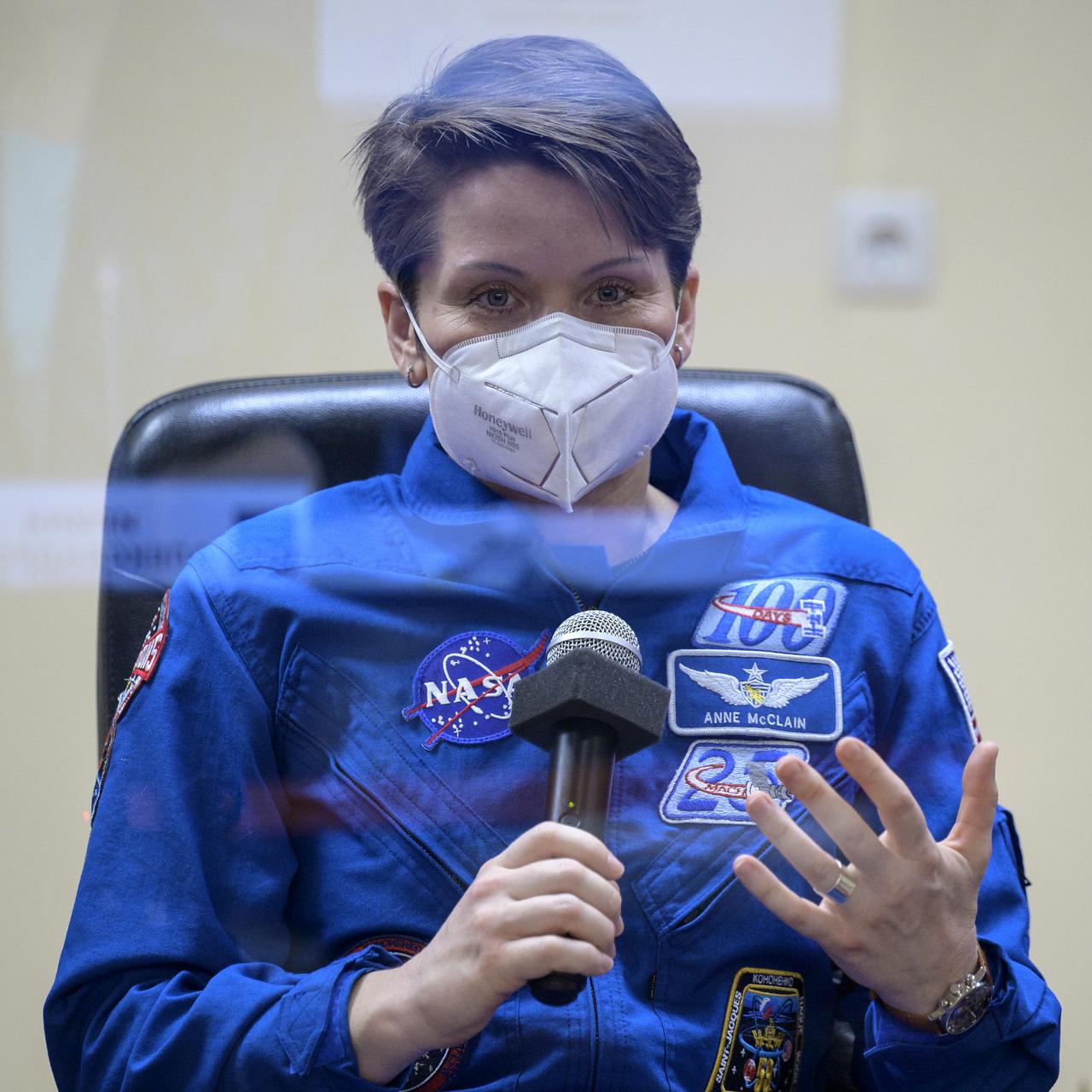 Expedition 65 backup crew member Anne McClain of NASA is seen in quarantine, behind glass, during a press conference, Thursday, April 8, 2021 a the Cosmonaut Hotel in Baikonur, Kazakhstan. Expedition 65 NASA astronaut Mark Vande Hei, Roscosmos cosmonauts Pyotr Dubrov and Oleg Novitskiy are scheduled to launch to the International Space Station aboard the Soyuz MS-18 spacecraft on April 9.  Photo Credit: (NASA/Bill Ingalls)