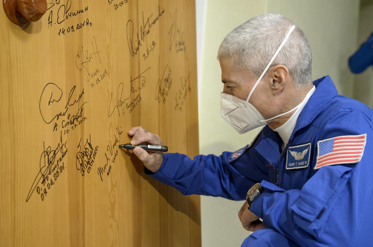 Expedition 65 NASA astronaut Mark Vande Hei performs the traditional door signing at the Cosmonaut Hotel prior to departing the hotel for launch on a Soyuz rocket with fellow crewmates Russian cosmonauts Oleg Novitskiy and Pyotr Dubrov, Friday, April 9, 2021, in Baikonur, Kazakhstan. Launch of the Soyuz rocket will sent the trio on a mission to the International Space Station. Photo Credit: (NASA/GCTC/Irina Spector