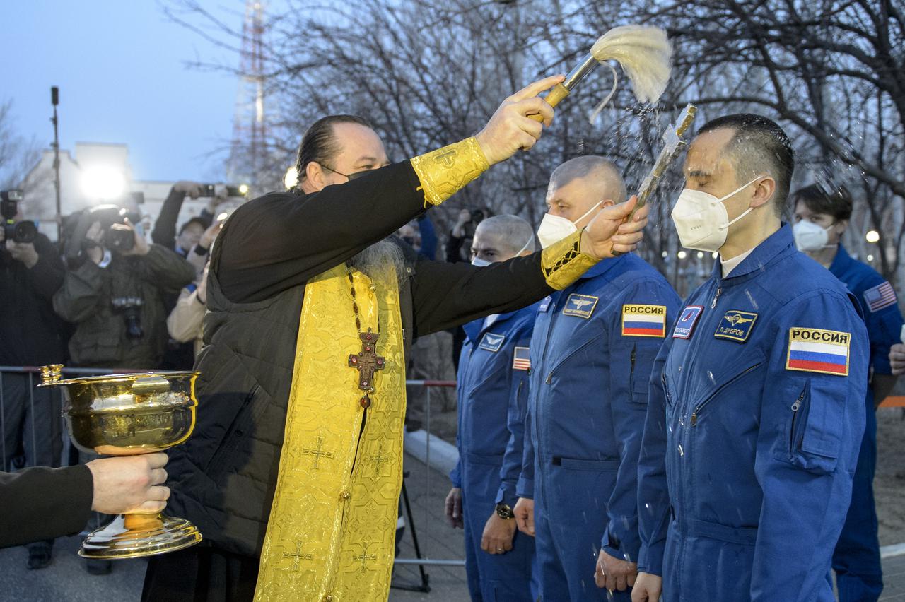 Russian Orthodox Priest Father Sergei performs the traditional crew blessing on Expedition 65 Russian cosmonaut Pyotr Dubrov and crewmates NASA astronaut Mark Vande Hei and Russian cosmonaut Oleg Novitskiy at the Cosmonaut Hotel as the crew departed the hotel for launch on a Soyuz rocket, Friday, April 9, 2021, in Baikonur, Kazakhstan. Photo Credit: (NASA/GCTC/Irina Spector